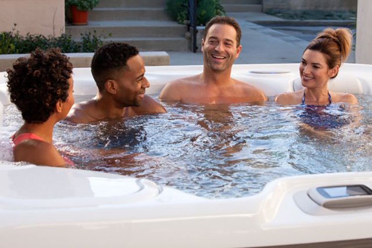  Friends relaxing and laughing together in a hot tub, enjoying a fun and social experience.