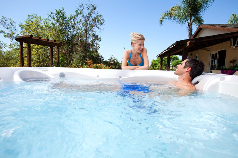 A couple summer hot-tubbing beneath the palm trees