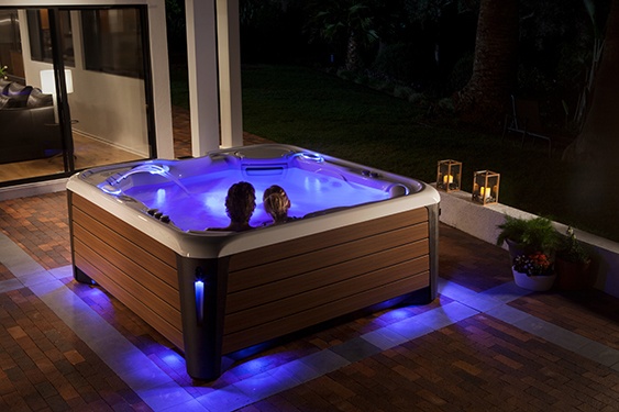 an image of a couple relaxing in a hot tub in a nighttime setting to prepare for a better night's sleep